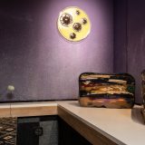 Interior of art gallery with sculpture of suitcase sliced in half on a plinth