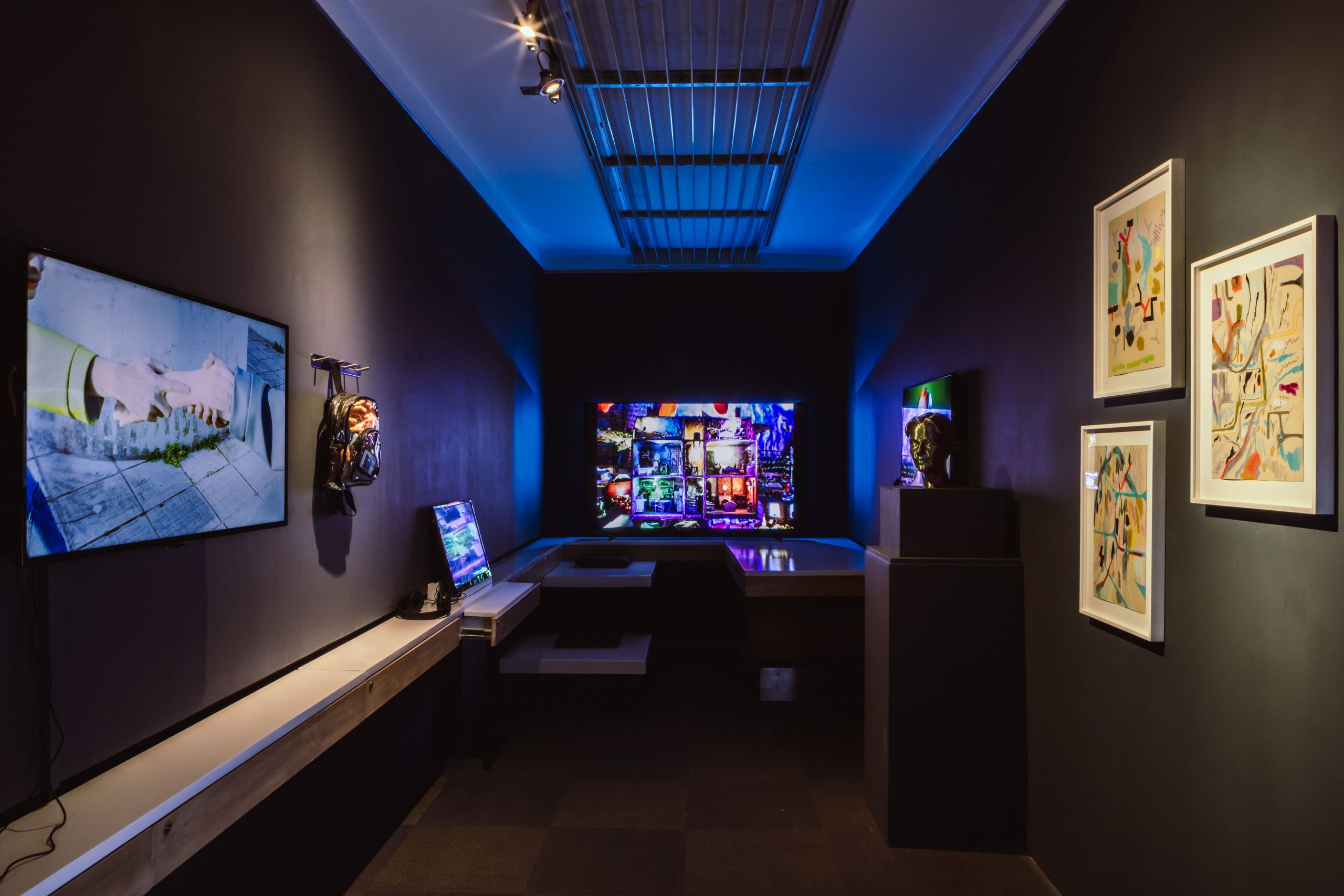 Interior of dark art gallery with multi coloured tv screens