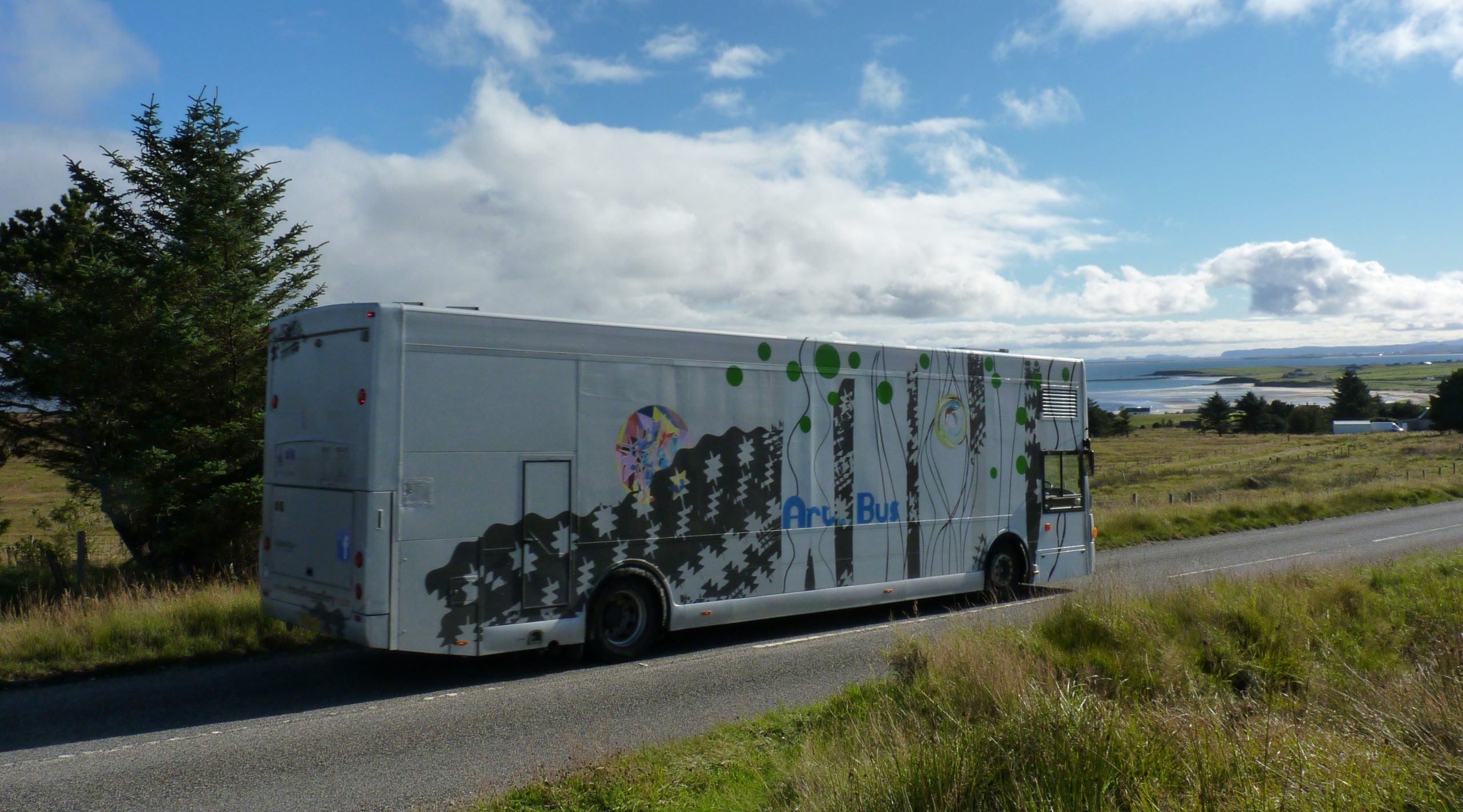 Travelling Gallery vehicle travelling down single track road towards a beach
