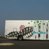 Travelling Gallery parked next to a tree on a hill top.